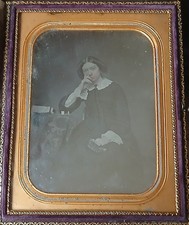 Daguerreotype Depicting A Woman In A Black Dress With White Collars At A Table