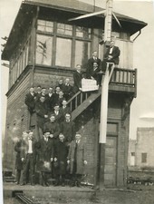 MEN IN SUITS STANDING ON STAIRS HOLDING SIGN 1921 WILL REWARD FIGHTERS.