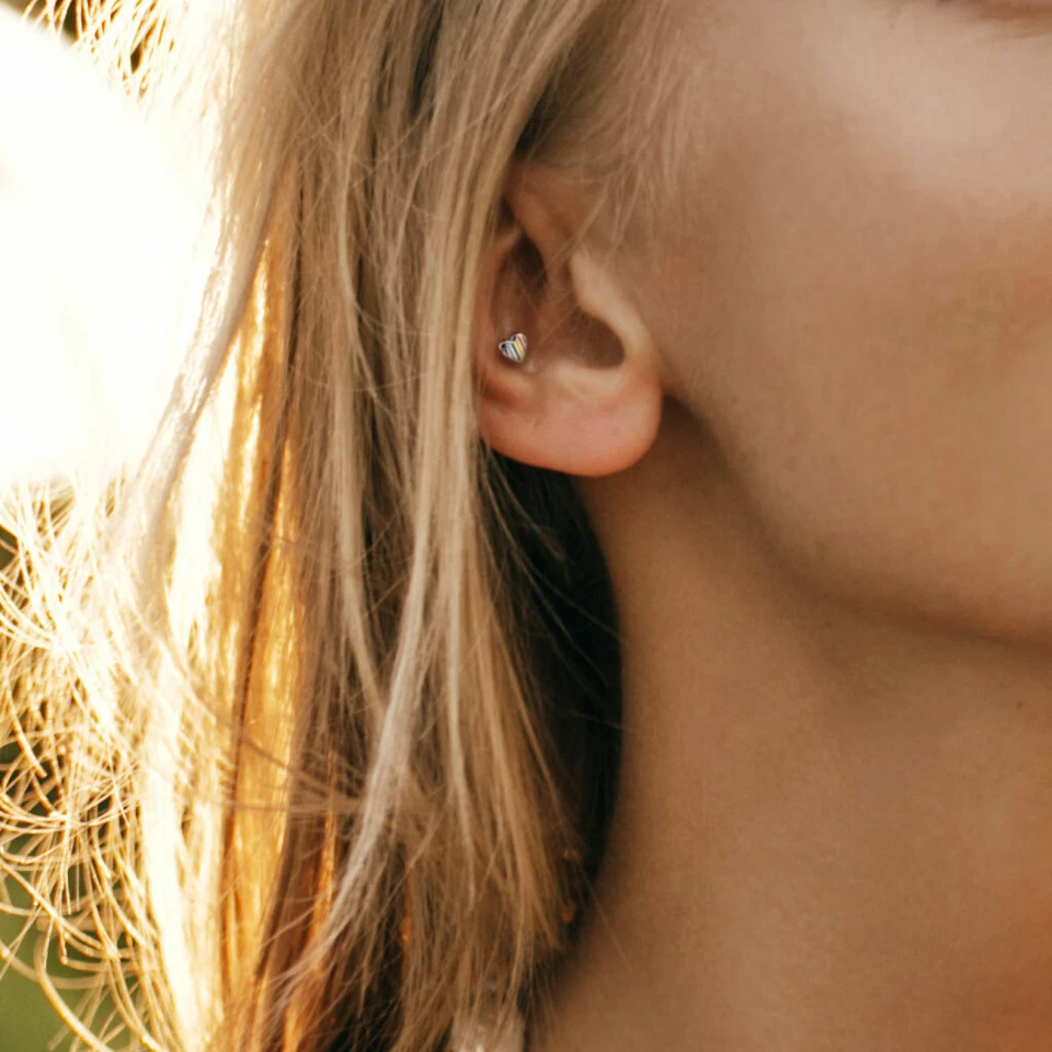 Piercing de cartílago tragus labio trasero plano roscado interno corazón a rayas arco iris Foto 2 de 4