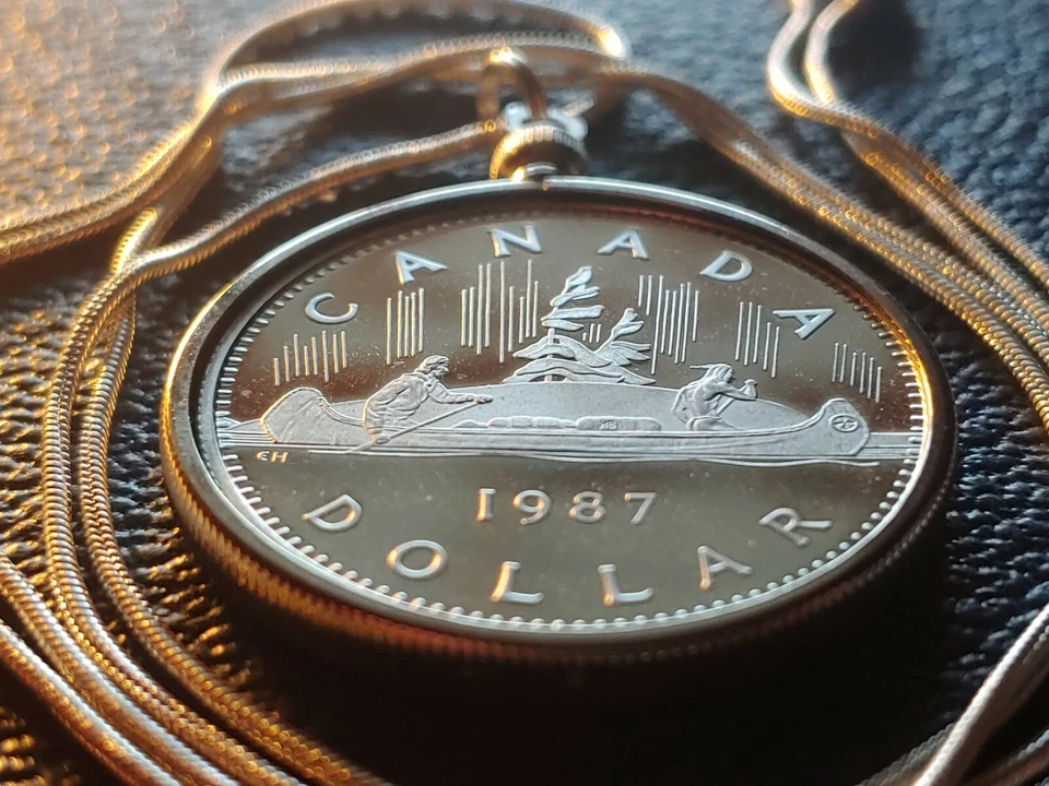 Colgante con bisel de moneda de dólar canoa 1987 de Canadá en una cadena llena de oro blanco de 28". Foto 2 de 4