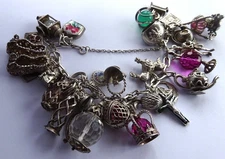 Vintage heavy solid silver charm bracelet &many curious silver charms inc moving