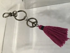The Sak silver tone hang tag charm with purple tassel