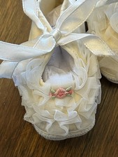 Vintage 1960s Mrs. Day's Ideal baby crib shoes with lace and ribbon details.
