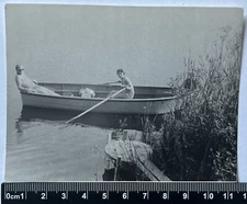 Young Shirtless Man In A Boat And A Woman In A Swimsuit On The Beach Old Photo