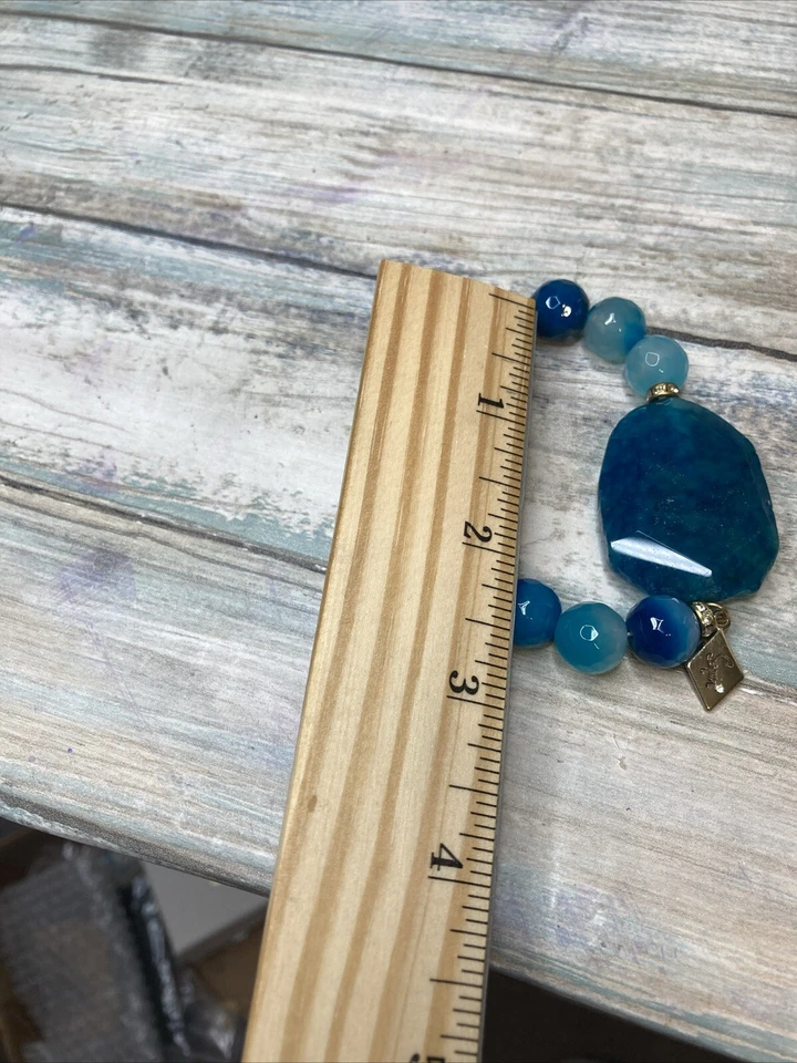 Pulsera elástica ágata azul de lentejuelas de diseñador. Diamantes de imitación con logotipo en tono dorado Foto 2 de 4