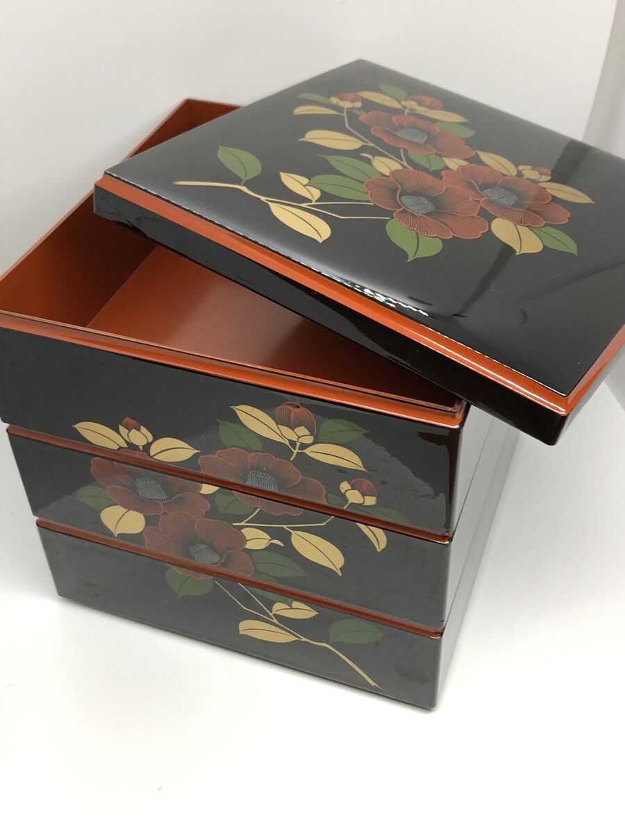 A Japanese Black Lacquer 4 Tier Bento Box with Gilt Floral Designs A Japanese Black Lacquer 4 Tier Bento Box with Gilt Floral Designs