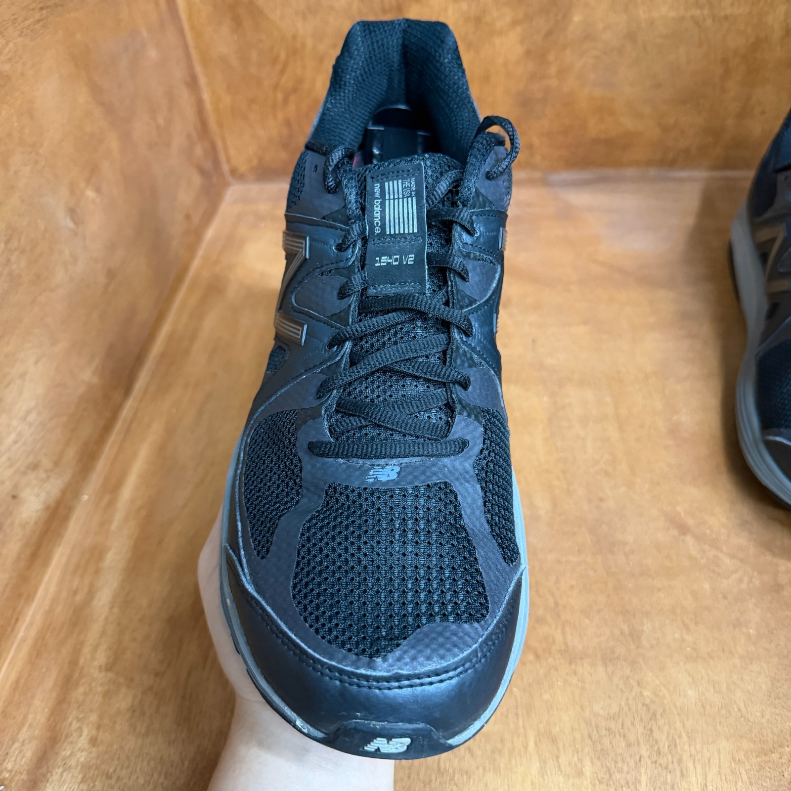 Black and gray New Balance 1540V2 men’s running shoes with mesh upper, suede panels, and “Made in USA” label on side.