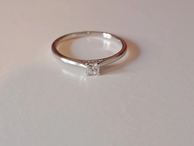 Anillo compromiso en oro blanco de 18 k. Diamante talla princesa de 0,15 ct