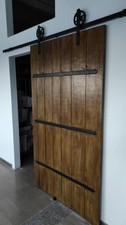 Porta scorrevole artigianale di legno massello con inserti in ferro battuto