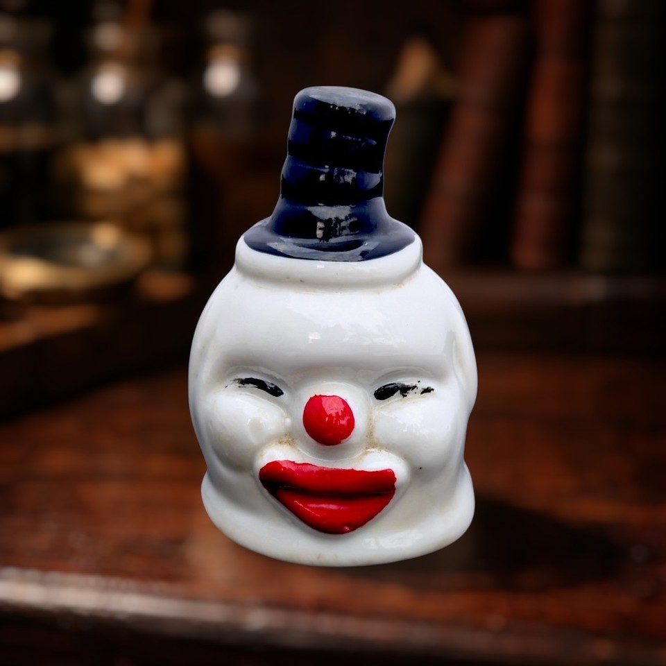 A creepy ceramic clown-head bell that lives in the exact sweet spot between circus nostalgia and unsettling oddity shelf art.