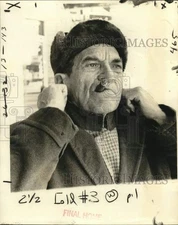 Press Photo A resident wears heavy coat, cap & scarves due to cold weather
