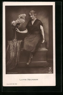 Actress Lotte Neumann sitting smiling on a dresser, postcard 