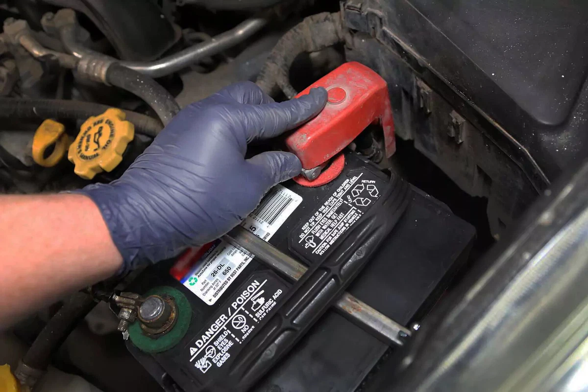 Installing a red cover over a battery terminal.