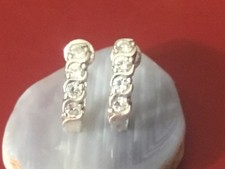 925 sterling silver huggie hoops set with small, round clear stones