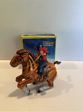 CLOCKWORK TIN COWBOY ON HORSE MADE IN KOREA.
