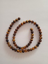 Oeil de tigre naturel d'Afrique . Lot de 60 perles de 6,4 mm - 114 carats.