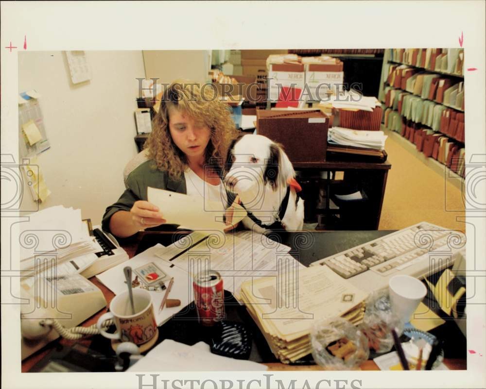 1993 Press Photo Bandit helps his owner Jenna Stewart work at Enron Corporation.