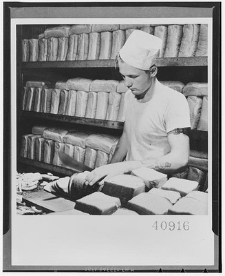 Photo:Bakery Worker 1900s Bread Loaves Shelves White Uniform Baking