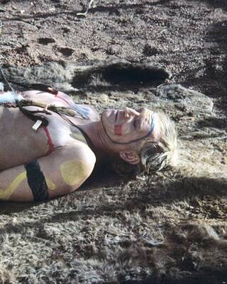 Richard Harris wearing face paint and body paint as he lays on an - Old Photo