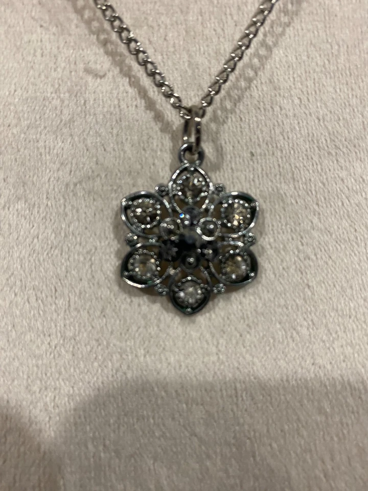 Dije de flores con cristales blancos y negros Foto 3 de 4