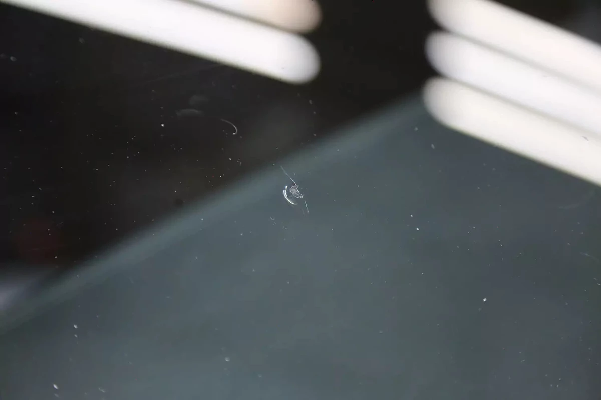 The repaired chip area of a vehicle's windshield.