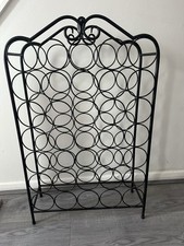 Free standing black metal wine rack, holds 28 bottles,  In excellent condition .