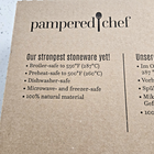 Brown box with white text from Pampered Chef 100251, “Our strongest stoneware yet!” and product features.