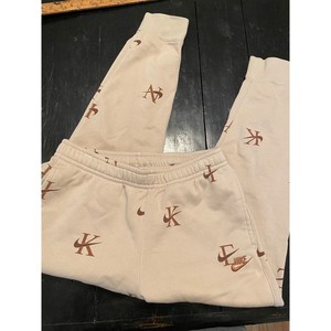 nike all over logo print joggers in camel