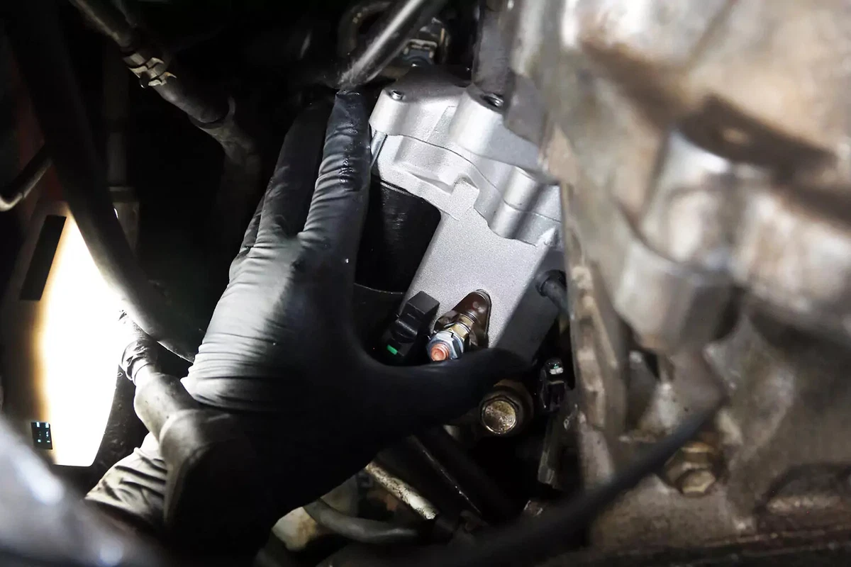 Hand-threading the bolts on the new starter.