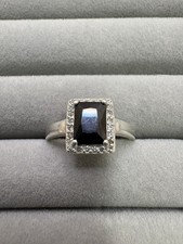 925 Sterling silver ring with a central black gemstone & smaller clear stones.
