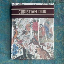 Christian Dior burgundy floral notebook featuring a decorative strap New