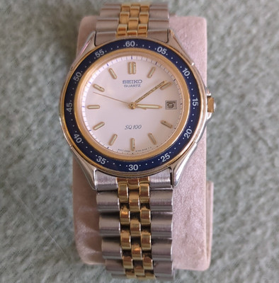 Seiko SQ 100 Quarz Analog Uhr Edelstahl Bicolor Blau Lünette Ref. 5Y22-6070