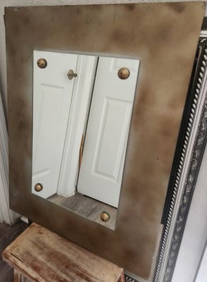 Metal Framed Mirror feat a rustic aged finish and decorative corner fastners