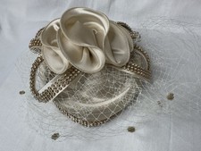 champagne-colored fascinator headpiece with a satin flower rhinestone trim, veil