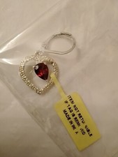 Heart shaped pendent ruby color stone lab created in center silvertone accent