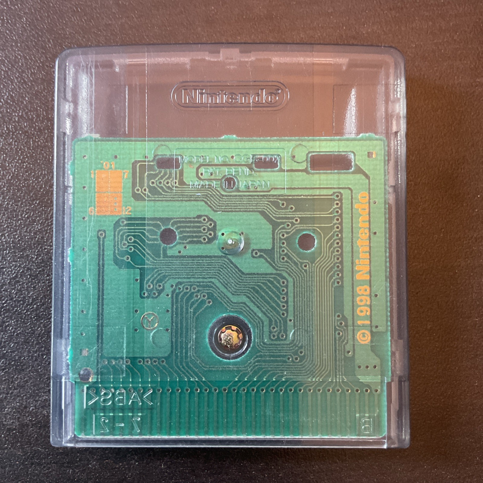Back panel of 2001 Monsters, Inc. Nintendo Game Boy Color showing green circuit board with silver connectors and Nintendo logo.