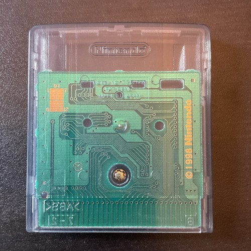 Back panel of 2001 Monsters, Inc. Nintendo Game Boy Color showing green circuit board with silver connectors and Nintendo logo.