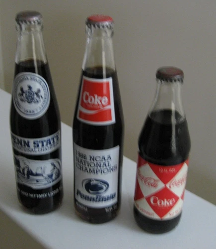 3 VINTAGE COCA-COLA BOTTLES 1982 PENN STATE CHAMP SEASON, 1986 NCAA CHAMPS, ETC