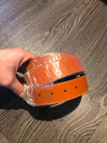Brown genuine leather belt with black stitching, silver H buckle, and visible stitching on white label.