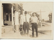 PHOTO OF MEN POSING W/ OLD GAS PUMP AT STATION