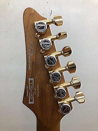 Gold Ibanez AZ47P2K Dragoneyeburst electric guitar with six tuning knobs and silver fretboard, used at the edge of the neck.