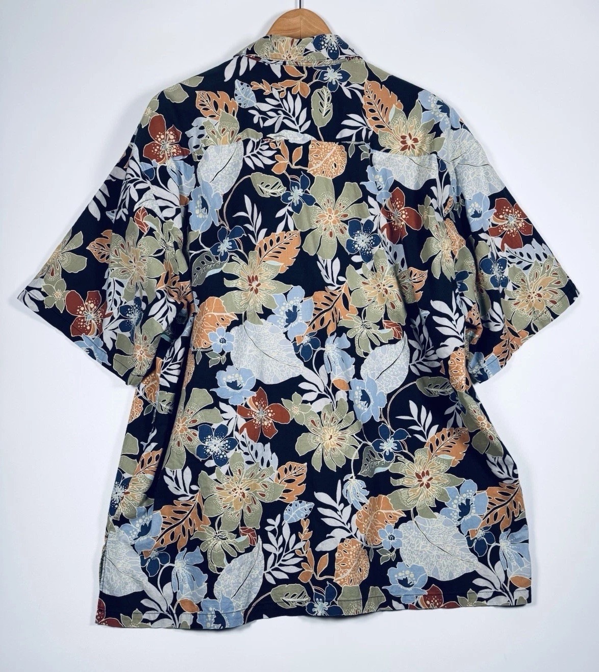 Black Hawaiian shirt men’s 2XL with orange, yellow, and blue floral print, green leaf background, and short sleeves.