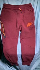 Red Marron Nike kids sweatpants with orange accents and zipper pockets