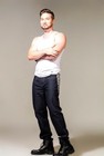 Man wearing black denim bootcut jeans with white tank top, crossed arms, and black lace-up boots, size 40x33.