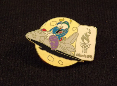 1996 ATLANTA OLYMPICS LAPEL PIN IZZY MASCOT RIDING SPACE SHUTTLE AROUND MOON