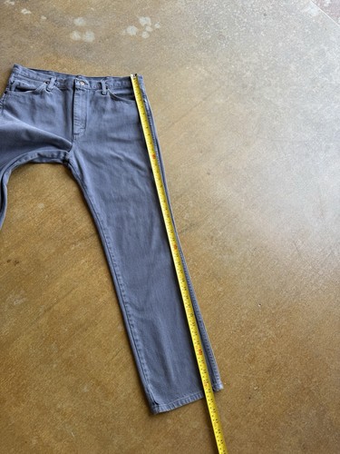 Gray VTG 90s Wrangler straight leg pants, 34Wx32L, on brown surface with yellow measuring tape.