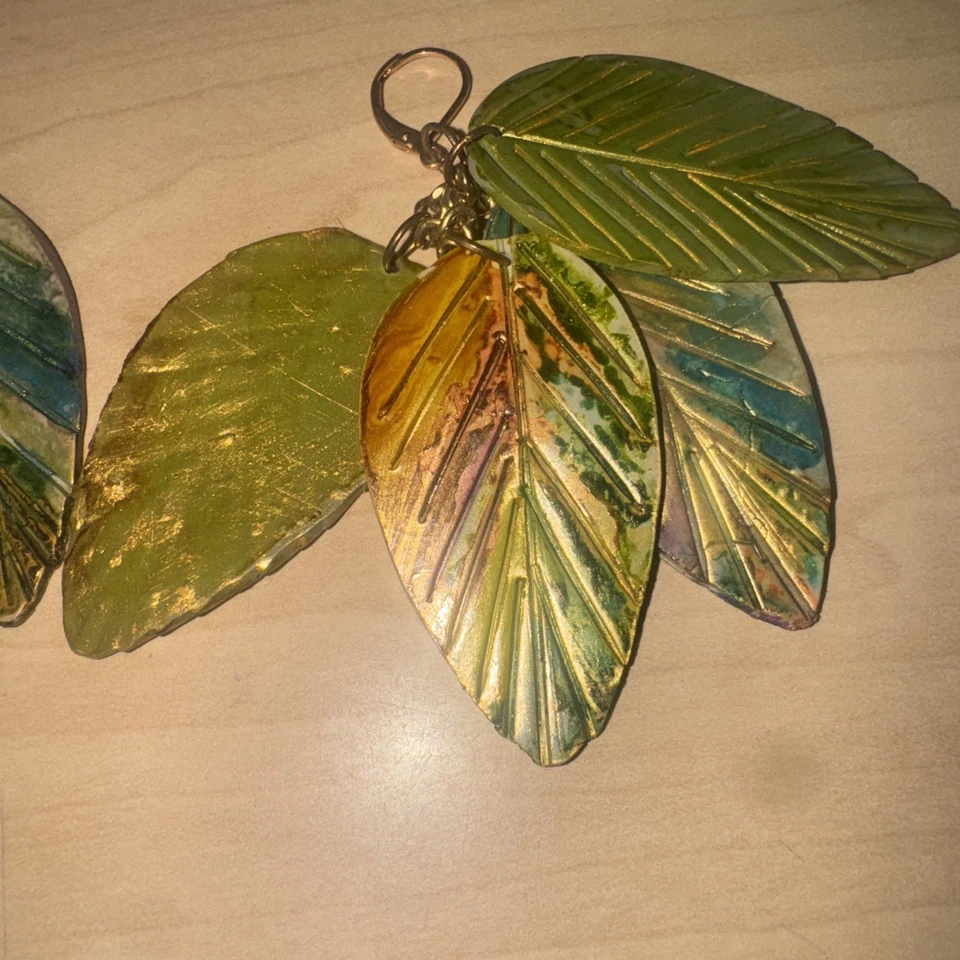 Pendientes colgantes de cuatro hojas de cuero metálicos pintados a mano Foto 3 de 3