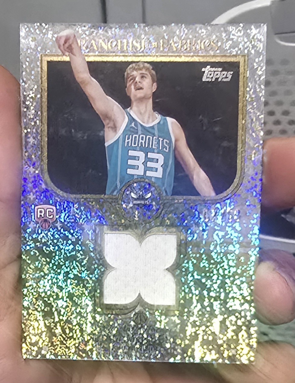 2025-26 Topps Franchise Fabrics Liam McNeeley #FF-LM Gold Holofoil /50 (MEM, RC)