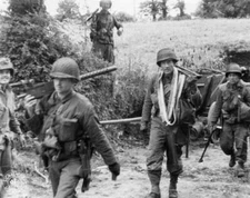 American paratroopers carry assault equipment along an unspecified- Old Photo
