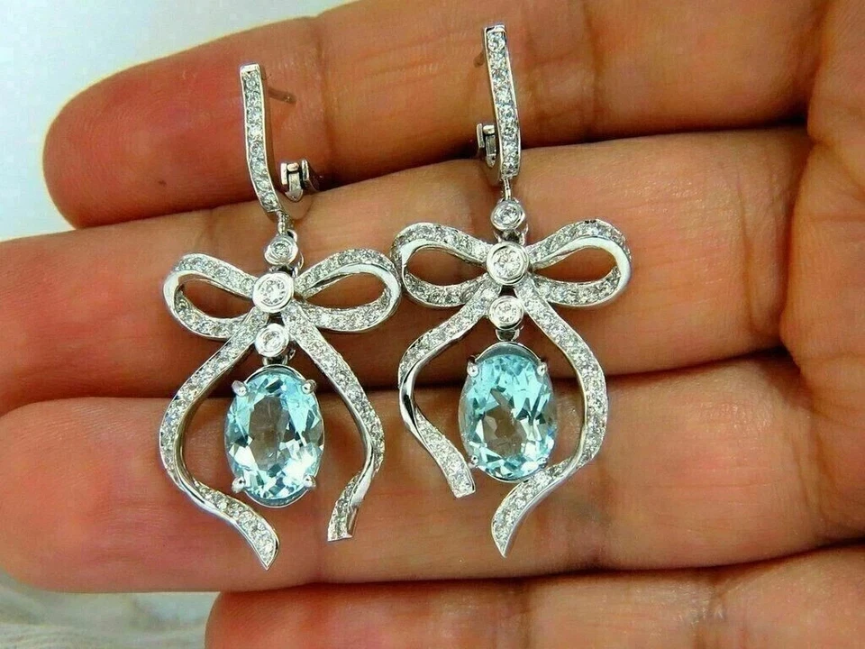 Pendientes colgantes de aguamarina simulada de corte ovalado de 4 quilates enchapados en oro blanco de 14 quilates Foto 2 de 3